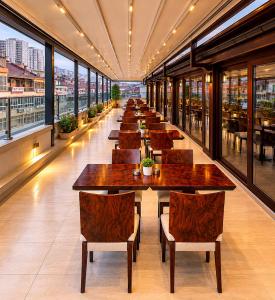 a row of tables in a restaurant with windows at Burcman Hotel in Bursa
