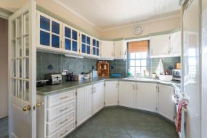 a kitchen with white cabinets and a window at Peace Valley Guesthouse in Napier