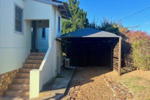 a garage entrance to a house with a black awning at Peace Valley Guesthouse in Napier +31 photos