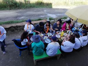 a group of people sitting around a table eating food at Syangbo Homestay in Nagarkot