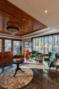 a living room with chairs and a table and windows at WelcomHeritage Elysium Resort & Spa in Shimla