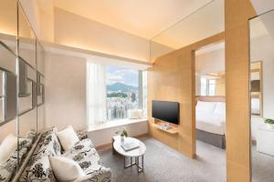 a room with a couch and a bed and a television at Dorsett Mongkok, Hong Kong in Hong Kong