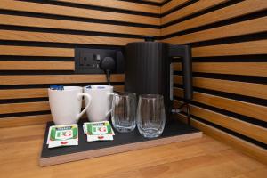 a coffee maker and two glasses on a tray at Amber Serviced Rooms - Free parking Self Check-In with access to shared kitchen in Hull