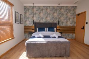 a bedroom with a large bed with blue pillows at Amber Serviced Rooms - Free parking Self Check-In with access to shared kitchen in Hull