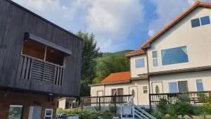 a house with a balcony and a building at Namhae Tovhouse Pension in Namhae