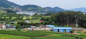 a small town on a hill with a river and mountains at Namhae Tovhouse Pension in Namhae