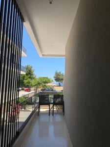 a balcony with a table and a view of a street at Alkida Luxury Rooms Tolo in Tolo