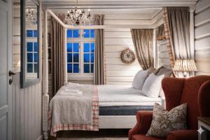 a bedroom with a bed with a chandelier and a window at Eggedal Borgerstue in Eggedal