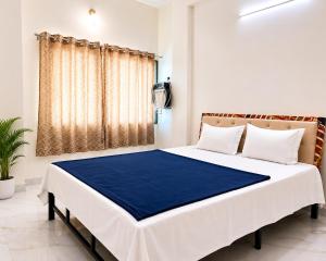 a bedroom with a large bed with a blue blanket at Hotel Prime Lodging in Aurangabad +20 photos