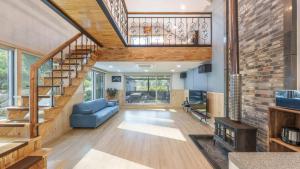 a living room with a staircase and a blue couch at Gapyeong The Hill Pool Villa in Gapyeong