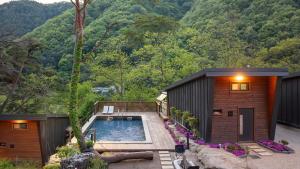 a house with a swimming pool next to a forest at Gapyeong The Hill Pool Villa in Gapyeong