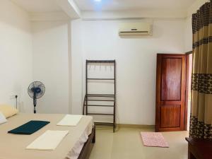 a room with a bed and a ladder and a fan at One More Night Hostel in Sigiriya