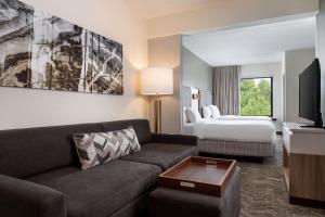 a hotel room with a couch and a bed at SpringHill Suites West Mifflin in West Mifflin +14 photos