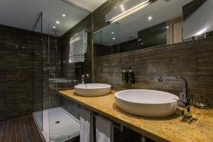 a bathroom with two sinks and a shower at Meliá Sevilla in Seville