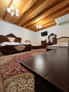 a large room with two beds and a table at Golden Minaret with Terrace in Bukhara