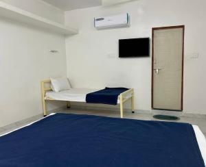 a room with a bed and a tv on the wall at Hotel Prime Lodging in Aurangabad