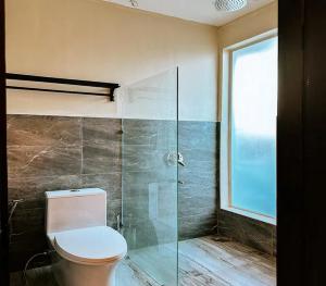 a bathroom with a toilet and a glass shower at The Ronin in General Luna +2 photos