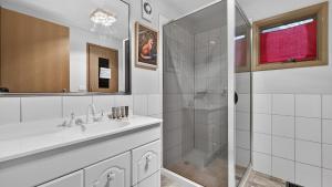a white bathroom with a shower and a sink at Coho in Dinner Plain +17 photos