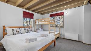 a bedroom with a bunk bed and two windows at Coho in Dinner Plain