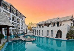 a pool in front of a building with a rainbow at Glond Hotel in Luang Prabang