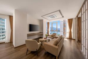 a living room with a couch and chairs and a tv at Petro Hotel Da Nang in Danang