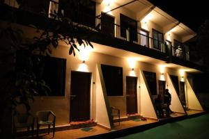a building with lights on the side of it at night at guest house carolina in Colva