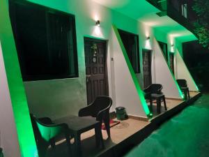 a room with green lights in a house at guest house carolina in Colva