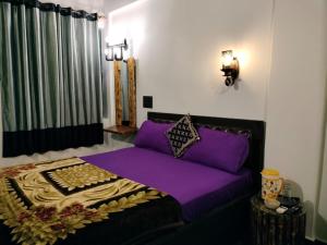 a bedroom with a purple bed in a room at guest house carolina in Colva