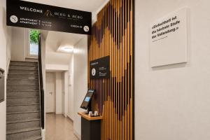 a hallway with a staircase with a yellow striped wall at BERG & BERG Apartments - Luzern Self-Check-in in Lucerne