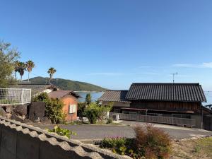 a building with a fence in front of it at 海辺の宿なみとけ in Shodoshima