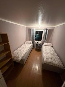 ein Schlafzimmer mit zwei Betten und einem Fenster in der Unterkunft Ravnklo in Sørkjosen