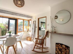 a living room with a fireplace and a table and chairs at West Island in Kingsbridge
