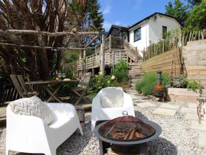 a backyard with two chairs and a fire pit at West Island in Kingsbridge