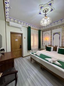 a bedroom with a large bed and a chandelier at Zarhal boutique Premium in Bukhara