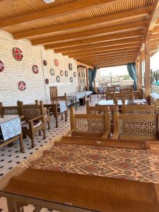 a restaurant with wooden tables and chairs and a brick wall at Zarhal boutique Premium in Bukhara +25 photos