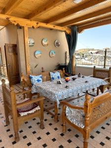 a dining room with a table and chairs and a balcony at Zarhal boutique Premium in Bukhara
