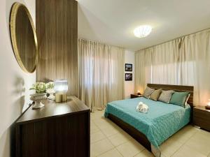 a bedroom with a blue bed and a mirror at Domino Blue Apartment in Paralimni +25 photos