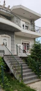 a house with stairs leading up to a balcony at ΚΑΡΔΙΤΣΑ οικογενειακο in Karditsa