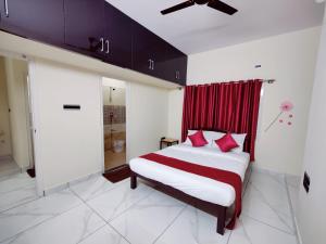 a bedroom with a large bed with red curtains at Mysore Studio Rooms in Mysore