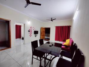 a dining room with a glass table and chairs at Mysore Studio Rooms in Mysore