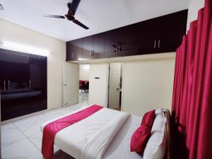 a bedroom with a bed with a red curtain at Mysore Studio Rooms in Mysore +3 photos