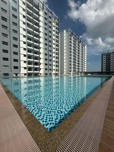 a large swimming pool in front of tall buildings at Pool View - H&A Signature Klebang in Malacca