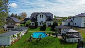 an aerial view of a house with a swimming pool at Fewo Traum, 4-Sterne FeWo's mit Pool und Whirlpool, Grillecke und neuem gemütlichen Pavillon im Garten, am Achterwasser mit Badestrand, wenige Autominuten bis zur Ostsee, Überweisung oder Bar akzeptiert in Neppermin