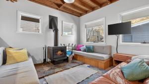 a living room with a fireplace and a couch at Feathertop in Dinner Plain
