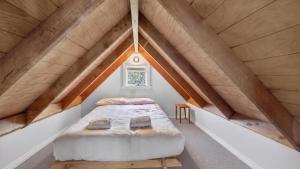 a bed in the middle of a room in a attic at Feathertop in Dinner Plain