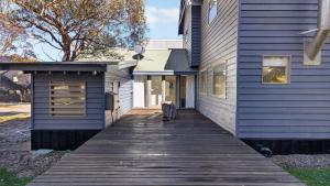 a wooden walkway leading to a blue house at Feathertop in Dinner Plain