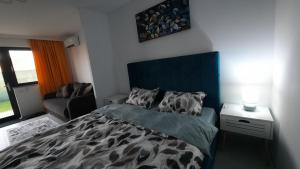 a bedroom with a bed with a blue head board at Casa Bon Relax , Rooms&Apartaments in Tuzla