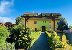 a yellow house with a pathway leading to it at Bořikovský Dvůr in Litovany