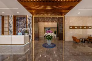 a lobby with a vase of flowers on the floor at Petro Hotel Da Nang in Danang +39 photos