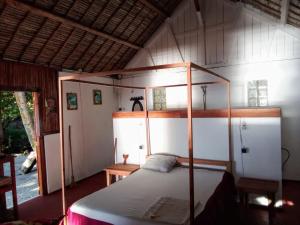 a bedroom with a canopy bed in a house at Bungalow Ambanivolo in Sainte Marie